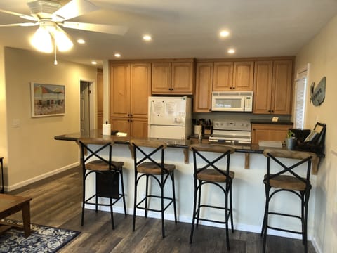 Kitchen with full length bar and 4 bar stools 