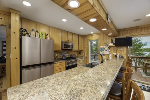 Well-stocked kitchen has Sonos, tv, & new sink, range, microwave, & fridge
