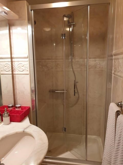 the luxurious marbled shower cabin  with  glass doors .