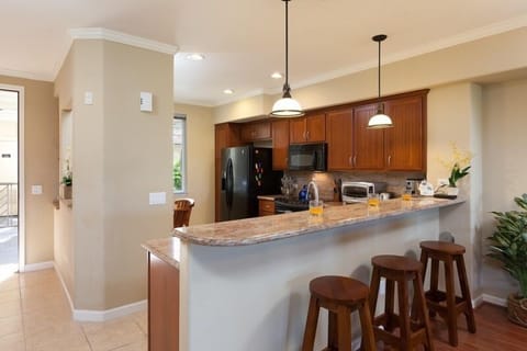 Full kitchen with breakfast bar, granite counters, and modern appliances