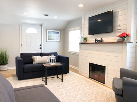 Spacious living room with plenty of seating, a flat screen TV and fireplace.