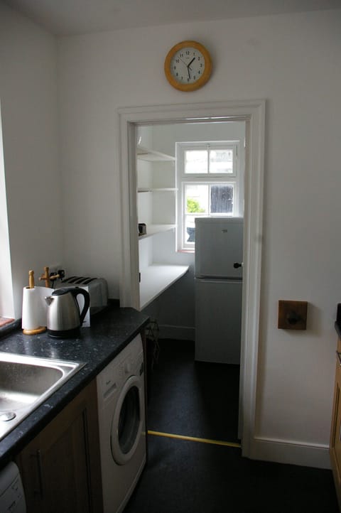 Kitchen with washer and dishwasher, looking into pantry.