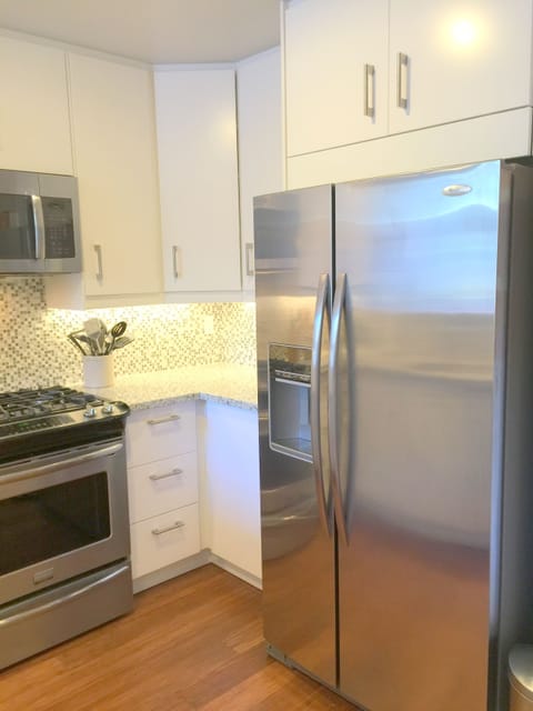 Family-sized refrigerator/freezer + adjacent pantry provides lots of storage