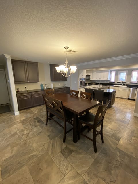 Large dining table close to kitchen and coffee/beverage bar. 