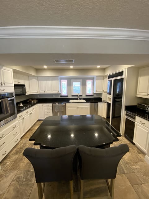 View of large kitchen with island and updated appliances.