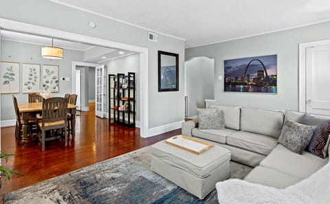 View of living room & dining room with sectional couch, welcome guide & blankets