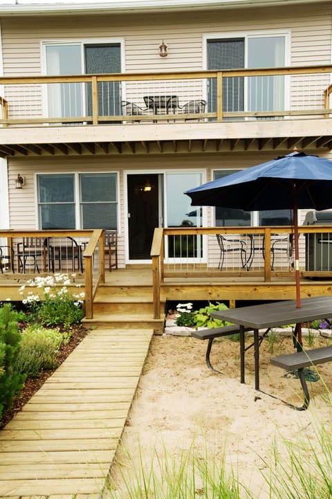 Lakeside view of house with upper balcony and lower deck.