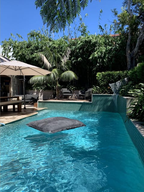 Outdoor pool & dining area surrounded by lush bamboo