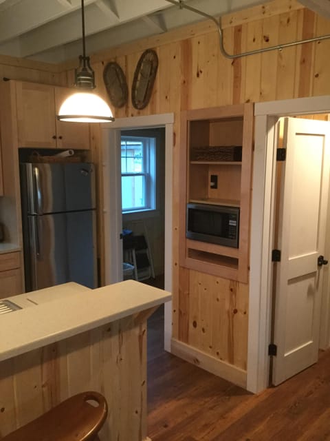 Open kitchen with fridge and microwave.