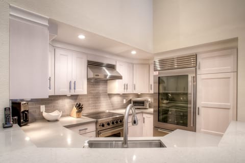 Designer kitchen fully stocked with spices and quality cookware.