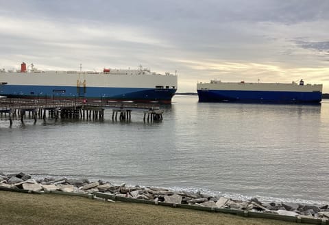 Vehicle carrier ships pass by condominium daily.  