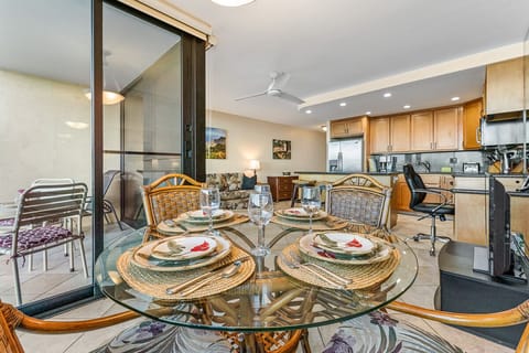 Dining area with round rattan and glass table and 4 matching chairs.