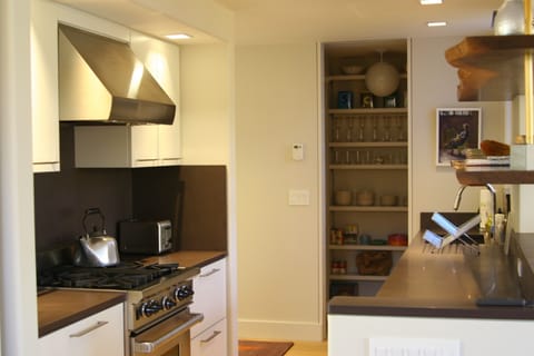 Kitchen with Wolf stove, under counter fridge and stocked pantry.