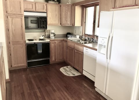 Kitchen equipped with cooking essentials. Empty cabinet space for your groceries