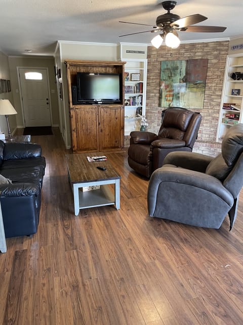 Living area with couch and recliners.