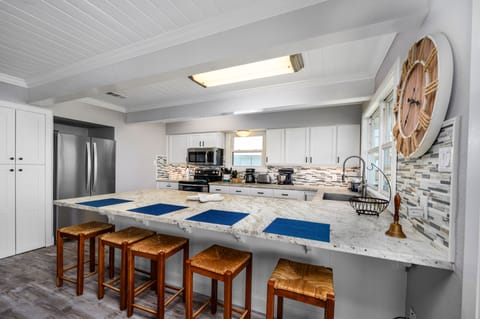 Updated kitchen with SS appliances, under-mount sink, and huge granite slabs.