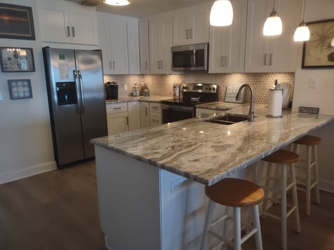 Recently remodeled kitchen with fully stocked kitchen appliances and utensils.