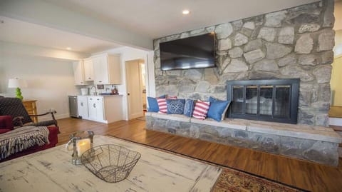 Basement gathering room complete with 55” smart TV, stone fireplace & wet bar. 