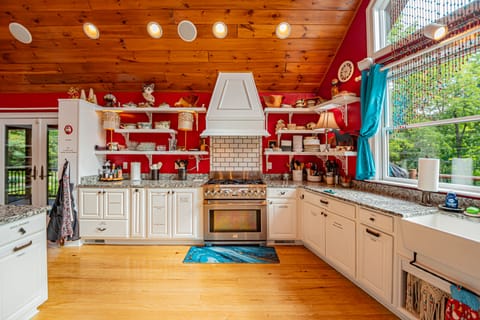 Main Level Kitchen convection stove, farm sink, and plenty of dinnerware
