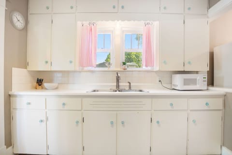 Fully stocked kitchen with dishes, utensils, and cookware. 