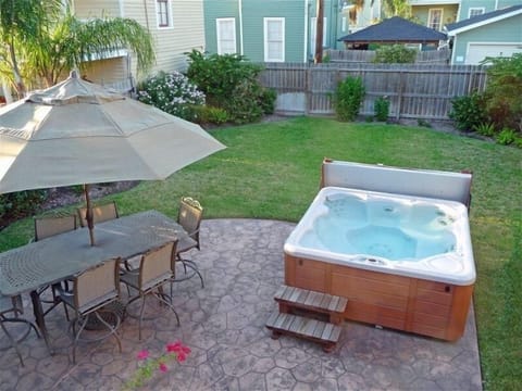 Beautifully landscaped back yard w/ patio furniture, barbeque grill, and hot tub