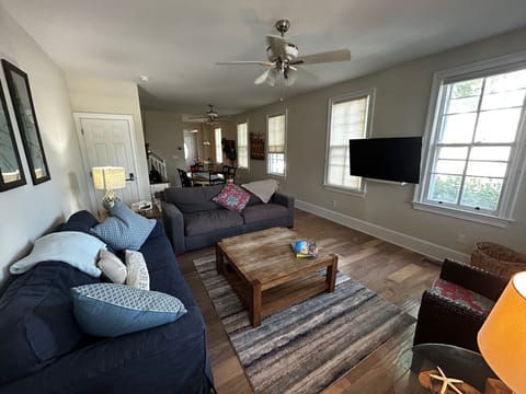 Large, open, bright living room.  Multiple couches and smart TV