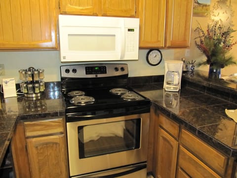 Kitchen is fully stocked with pots, pans, plates, etc.