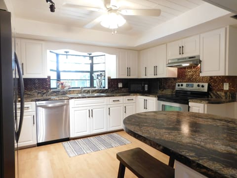 large kitchen with plenty of supplies and stainless appliances to use..