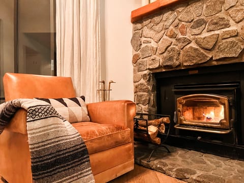 Cozy up to the wood burning fireplace in vintage leather chairs