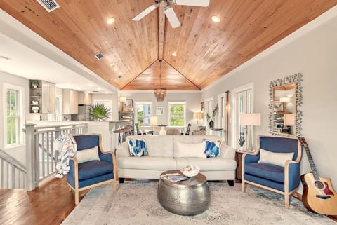 Great room, pecky cypress, quartz bartop, porches, treetop views, coastal vibes.