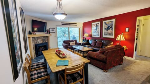 Living room w/ gas fireplace, sofa bed, and balcony w/ propane BBQ grill
