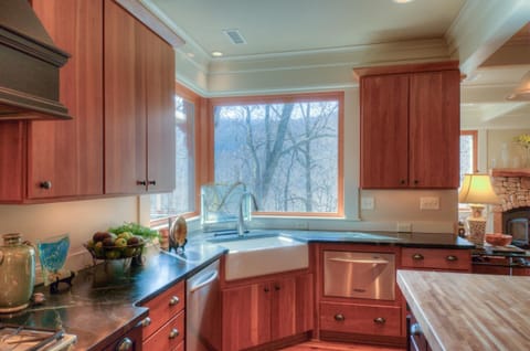 Fully stocked gourmet kitchen with mountain views and connection to living area.