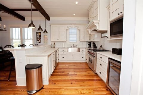 Gourmet kitchen with Wolf Gas Range, wine fridge, and Carrera marble counters.