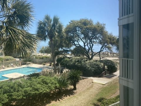 View of ocean and pool from screened in porch
