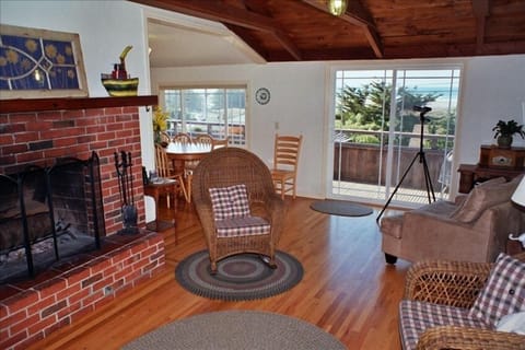 Open concept living room with vaulted ceiling & fireplace ready for you to light