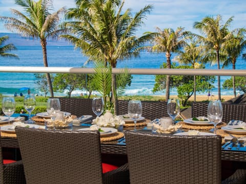Dine in luxury with a beautifully arranged table on your lanai, surrounded by lush greenery and overlooking Maui's pristine shoreline.