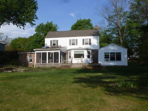 View of back of house showing screened in porch and deck, taken from back yard