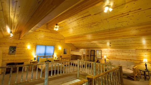 The loft, with a queen size bed, twin bunk beds, futon, desk and library.