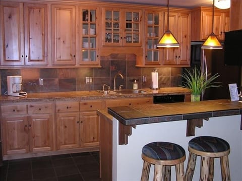 Full Kitchen with heated tile floor, stove, refrigerator, microwave, etc