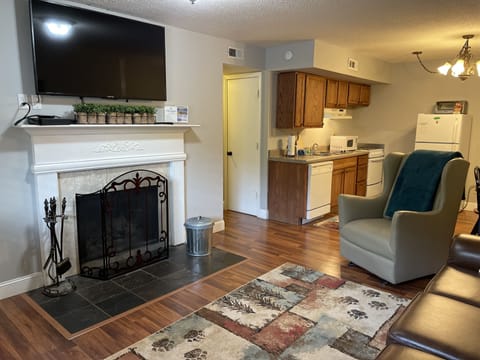 Living Room with wood burning fireplace and kitchen area shown