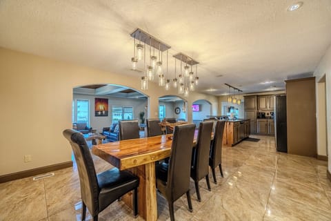"Open dining area with a wooden table, pendant lighting, and kitchen access."