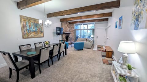 Living room w/ dining table, wood fireplace, and balcony w/ propane BBQ grill