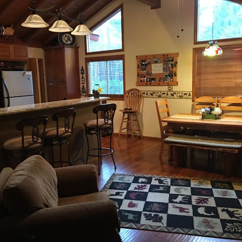 kitchen/dining room with comfy oversized chair in front of wood stove.
