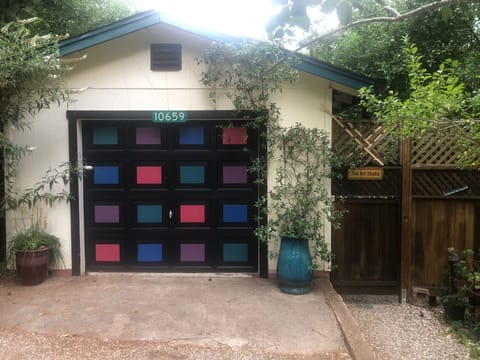 Park in front of the garage with sign 10659 and The Art Studio sign on gate