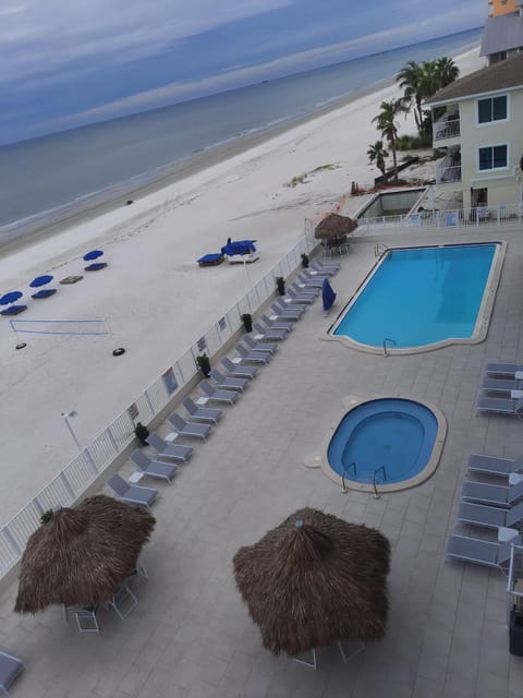 Large beachside pool and hot tub with tiki huts