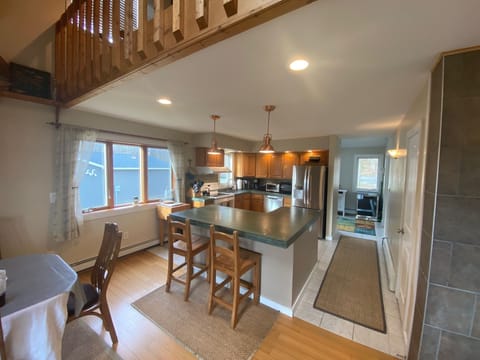 Kitchen, with concrete countertops, large island with stool, updated appliances.