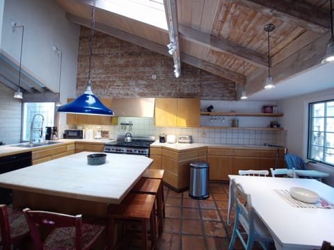 Kitchen. Large island on left w 3 stools