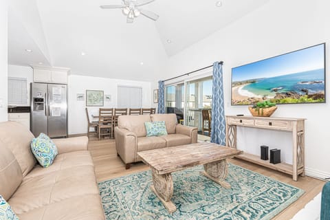 The main living area seamlessly flows from kitchen, to dining, to porch area. It includes a leather sofa set, cable TV, dining table for 6-8.