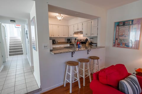 Breakfast counter bar with seating for 3 and a view of the hall to the stairs