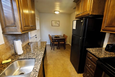 Kitchen view into cozy dining area with seating for four guests.